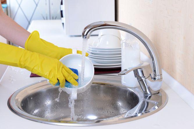 Close up hands of woman washing dishes in kitchen — Photo